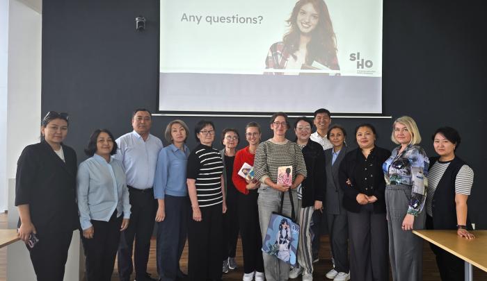 foto van delegatie uit Kazachstan (personen). op de achtergrond een powerpoint met het siho logo